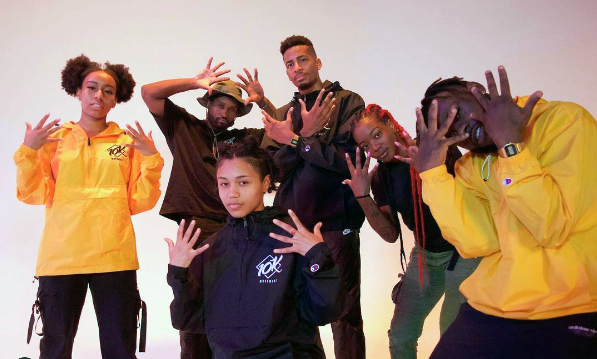 Dance troup of 6 in various poses holding up 10 fingers